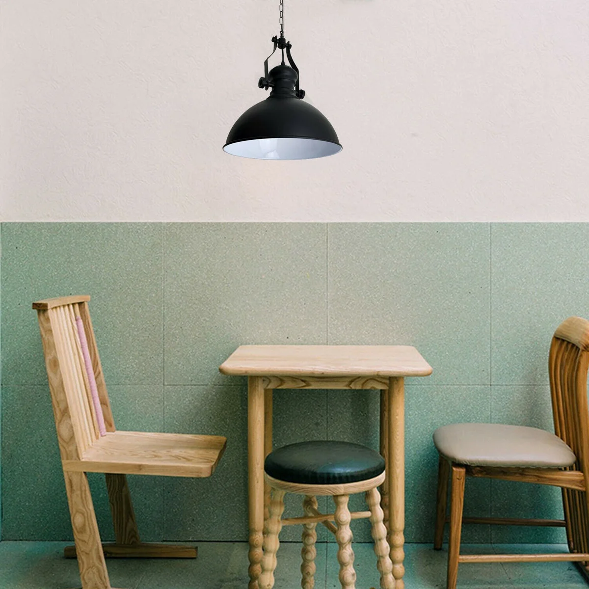 Retro industrial ceiling light with black metal dome shade and adjustable chain hanging in a modern loft setting