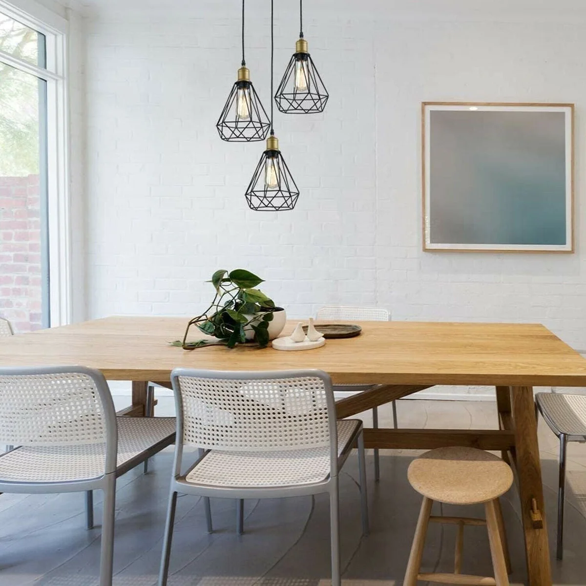 Black industrial cage pendant light with three geometric metal shades hanging from adjustable cords