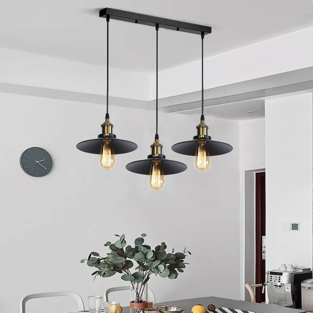 Modern black pendant light with three vintage retro style lampshades hanging from adjustable cords and brass ceiling rose