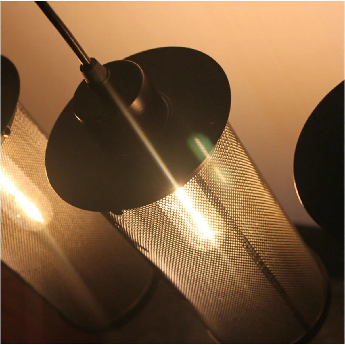 Three black perforated metal industrial pendant light shades clustered with cables and ceiling rose fitting accessories