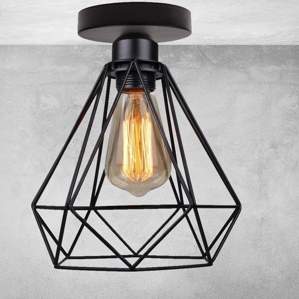 Black vintage industrial pendant lamp with metal cage and glowing E27 bulb ceiling light in a living room setting