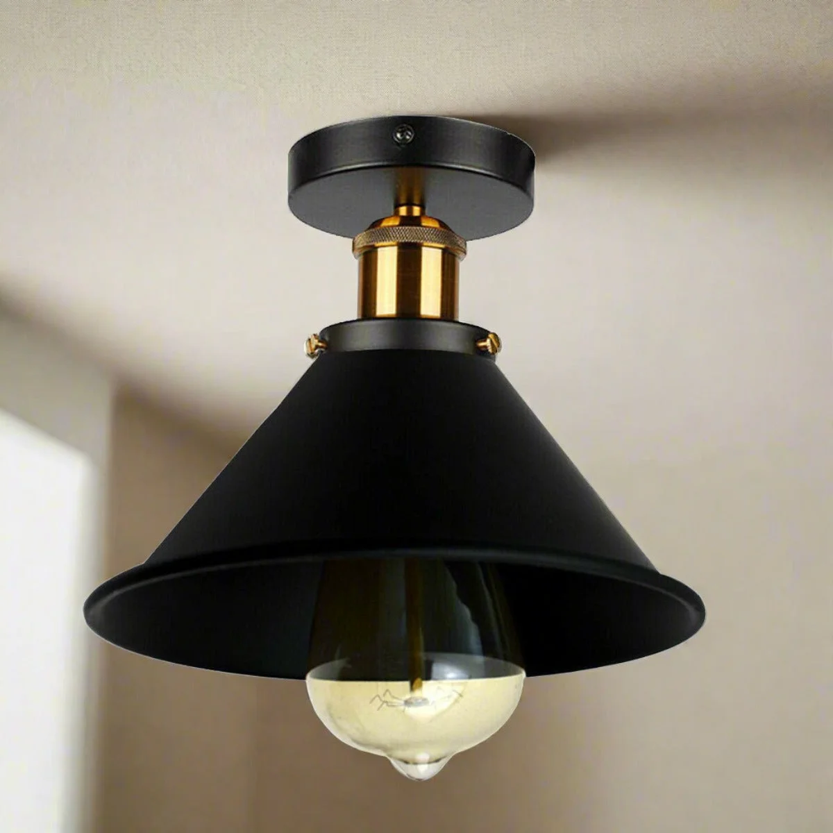 Black industrial semi-flush ceiling light with conical metal shade and gold brass accents, E27 bulb holder visible