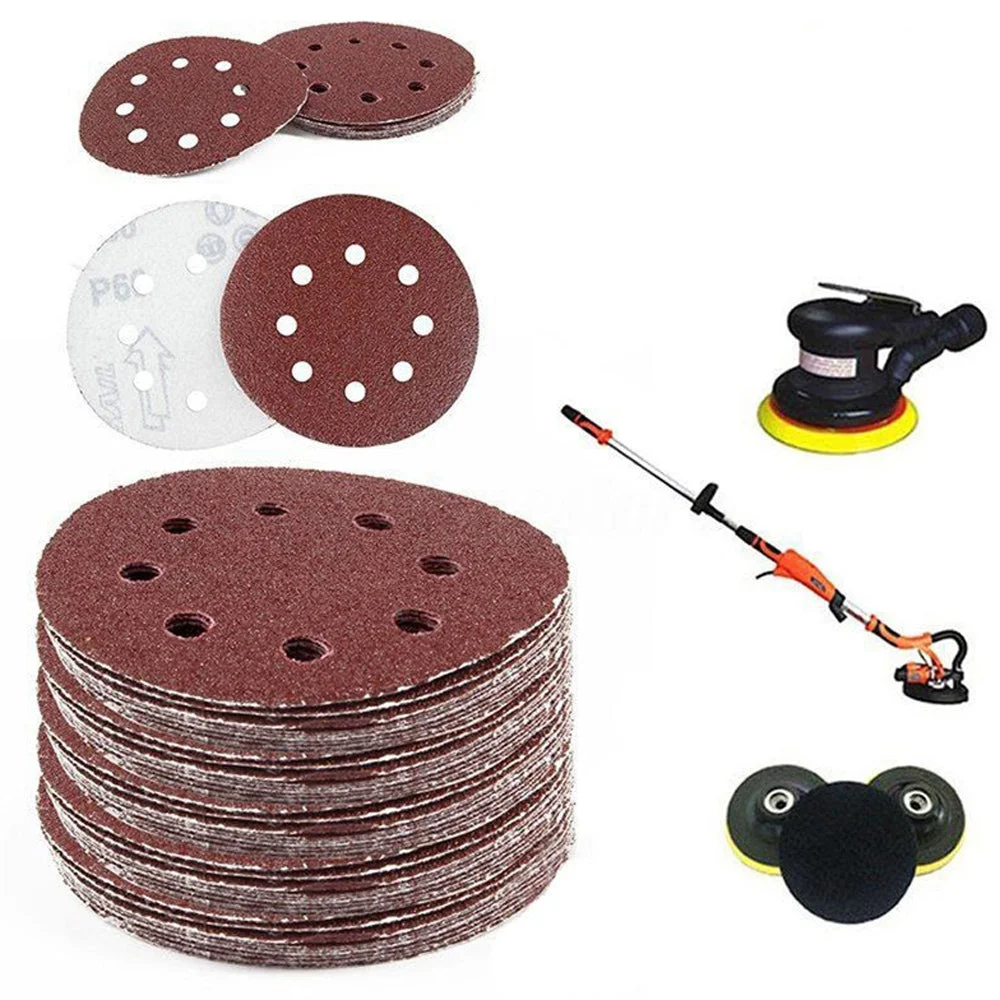 Set of 5 reddish brown 5 inch aluminum oxide sanding discs with 8 holes and hook and loop backing on white background