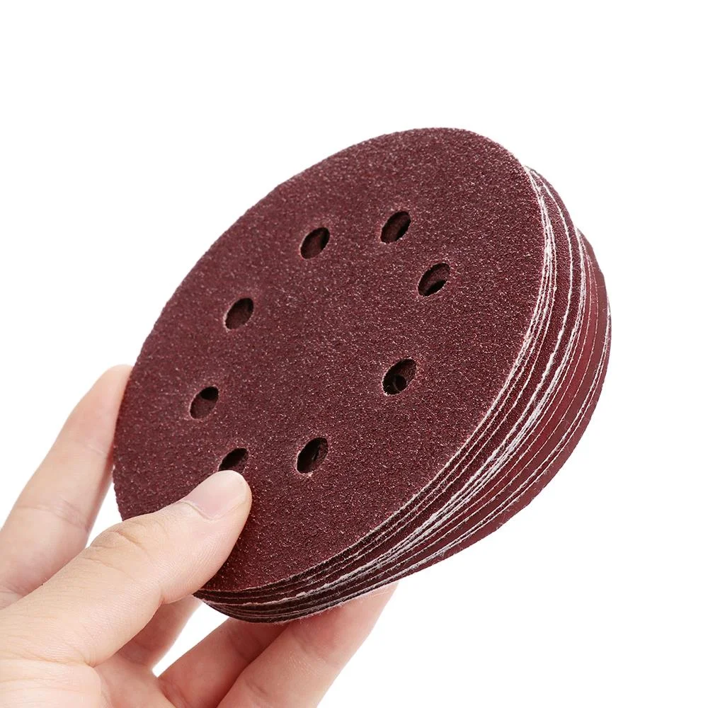 Stack of reddish brown 125mm sanding discs with 8 holes, 60 grit, designed for woodworking and metalworking tasks