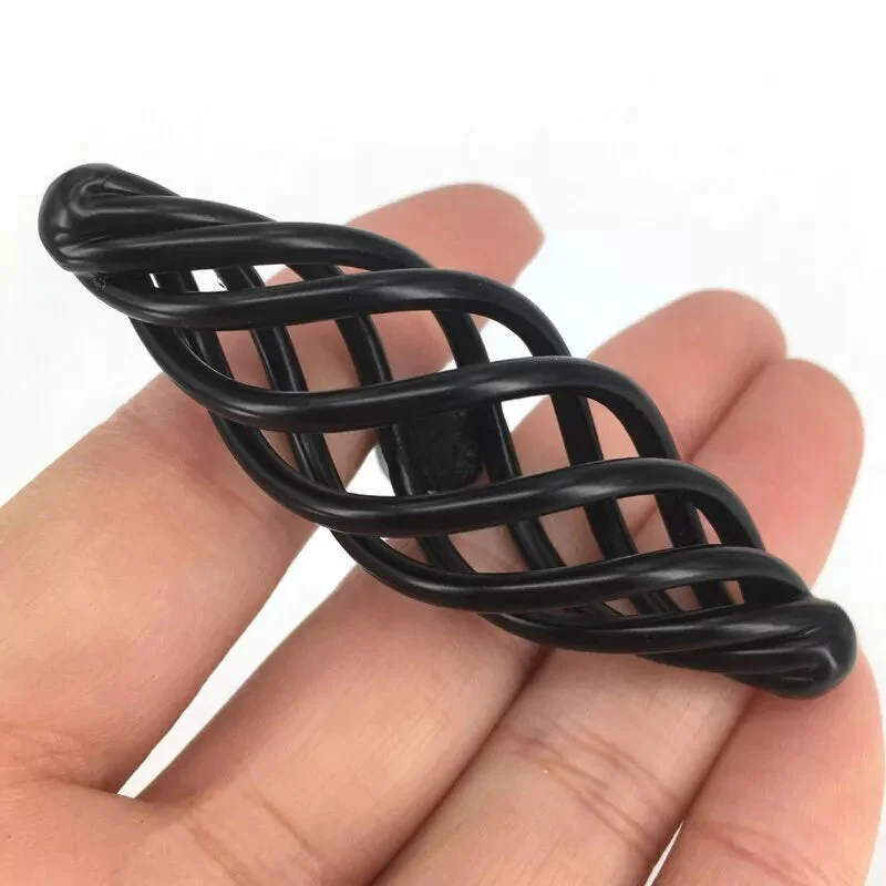 Close-up of vintage black metal cupboard pulls with birdcage design, matte finish, ideal for cabinets and drawers