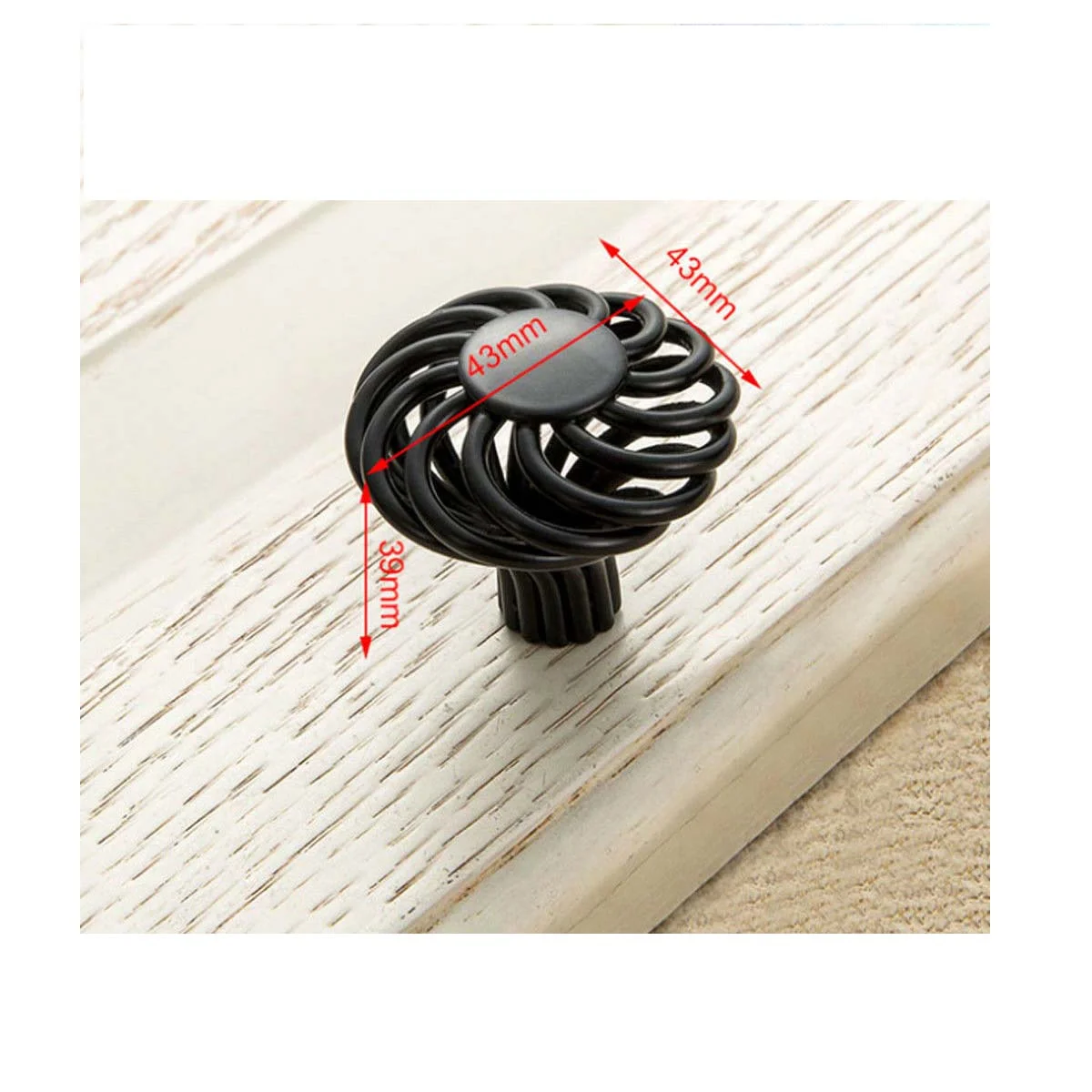Black iron birdcage kitchen cabinet knob with matte black finish on wooden drawer front, vintage decorative style
