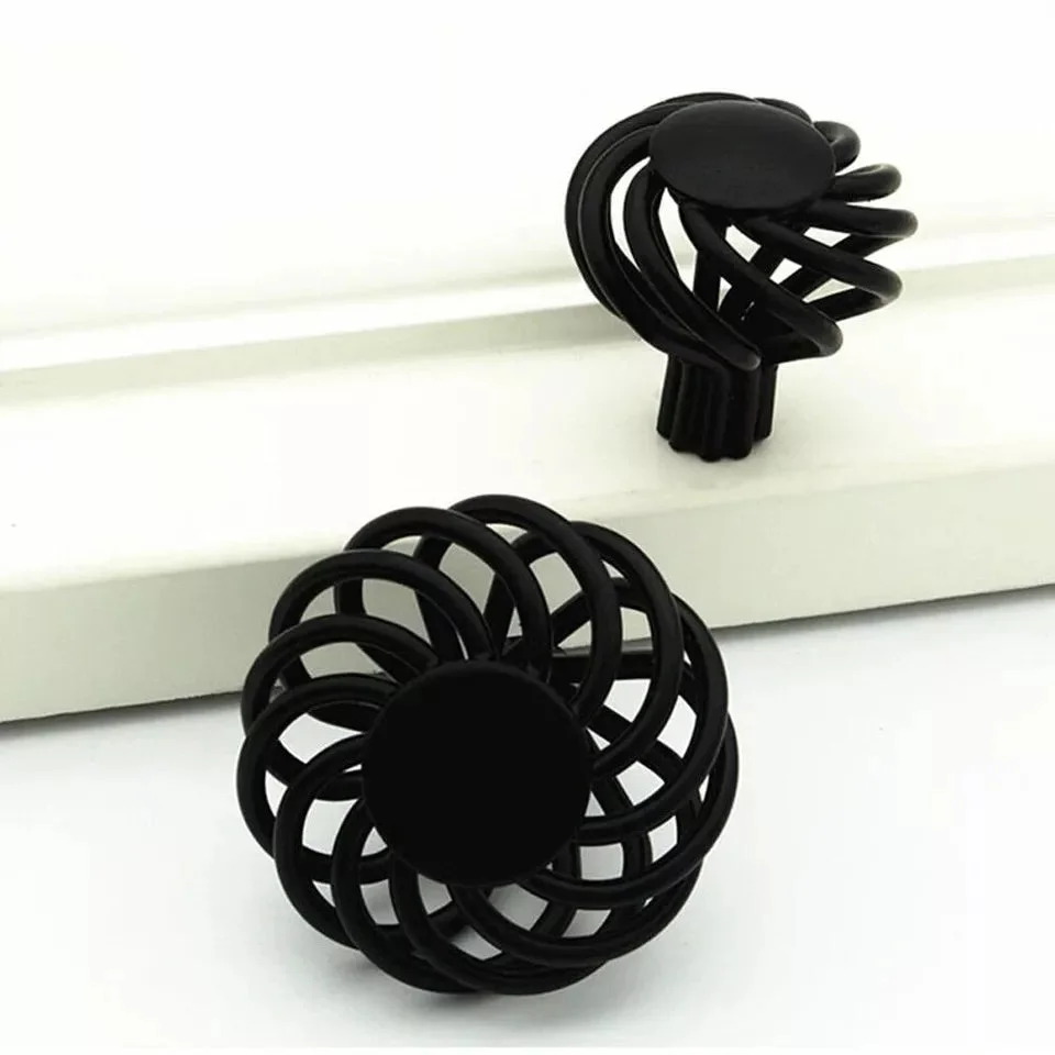 Black iron decorative drawer handle shaped like a birdcage, 35mm diameter, matte black finish on wooden drawer front