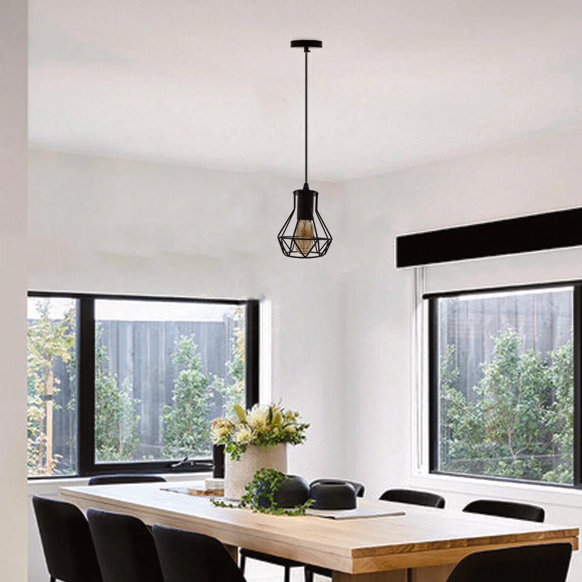 Modern black metal cage pendant light hanging from ceiling with exposed bulb and 95cm PVC cable against white background