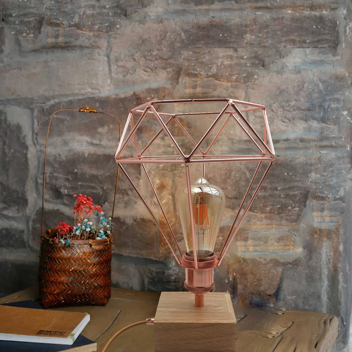 Rose gold table lamp with geometric wire cage design, slim base, and visible LED bulb socket on white background