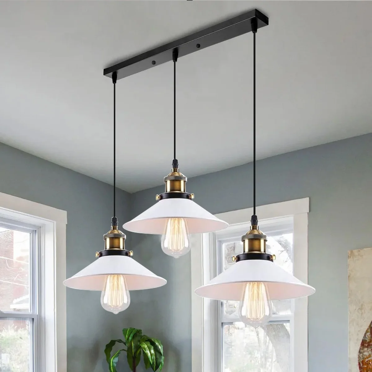 Adjustable ceiling pendant light with three rectangular black and white metal shades and twisted cables hanging from ceiling plate