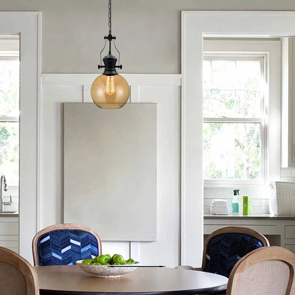 Amber glass industrial pendant light with black cage, round ceiling plate, and 90cm chain suspended from ceiling
