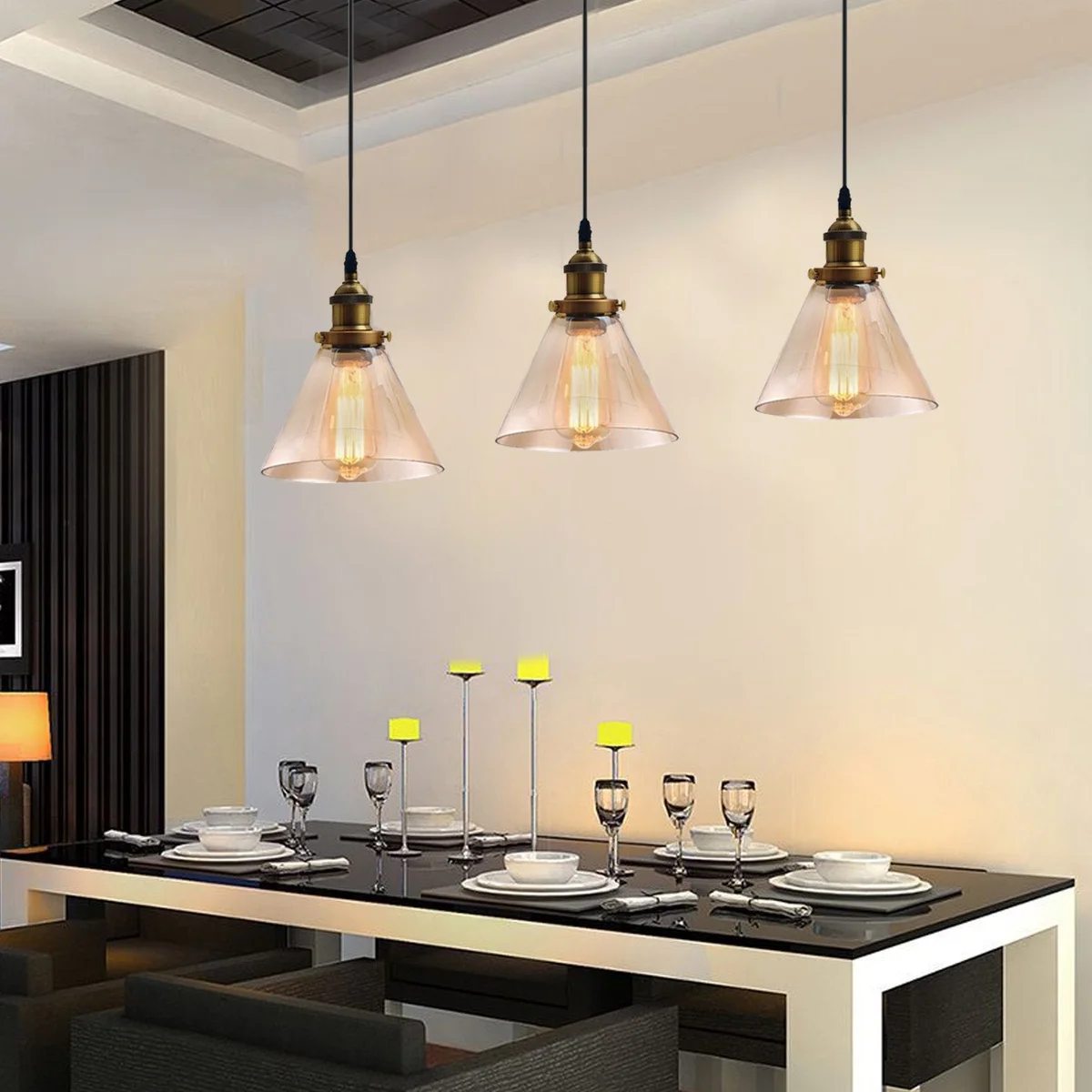 Industrial pendant light with three amber glass lampshades suspended from a black metal frame.