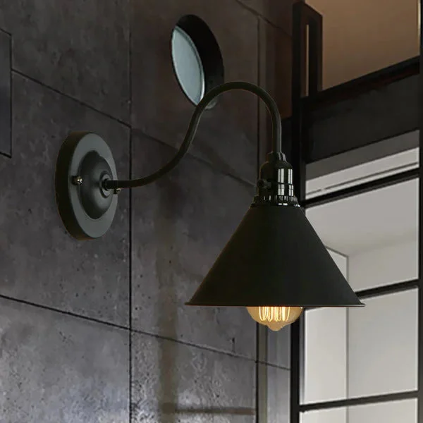 Black industrial style iron wall lamp cage with cone shade and E27 holder mounted on a wall