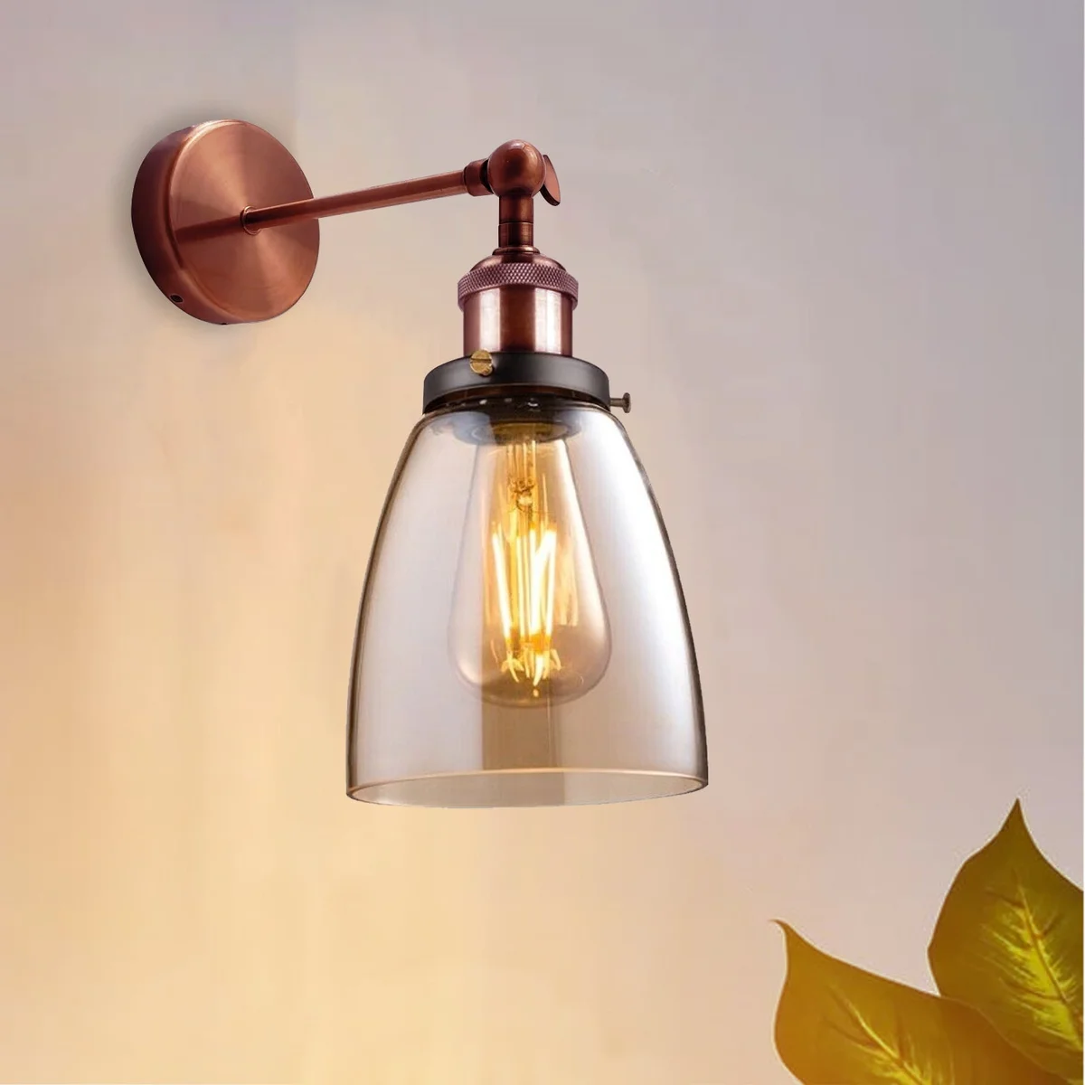 Amber glass wall light with copper plated base mounted on wall, featuring a glass shade and decorative copper plate