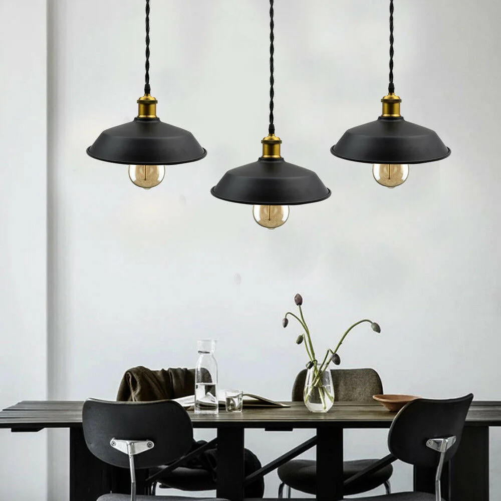 Three black round fabric vintage pendant ceiling lights with black wire cables displayed on a living room wall.