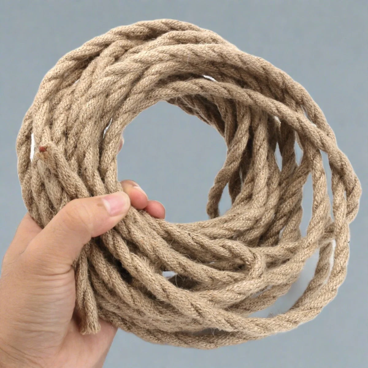3‑core hemp fabric indoor lighting cable, twisted, 6mm diameter, coiled and attached to a pendant lamp.
