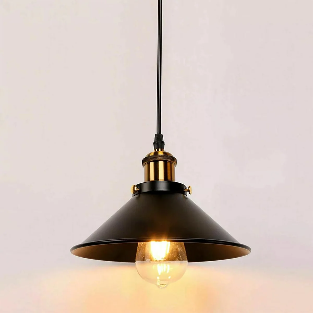 black pendant light with round black shade, gold lamp holder and black fabric hanging cord