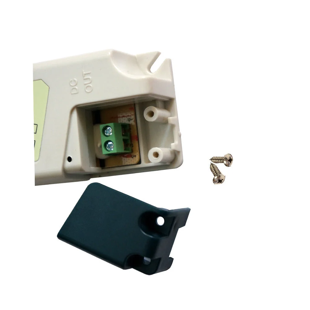 Compact plastic LED strip light transformer with screw terminals, mounted on wall using screws, protective casing.