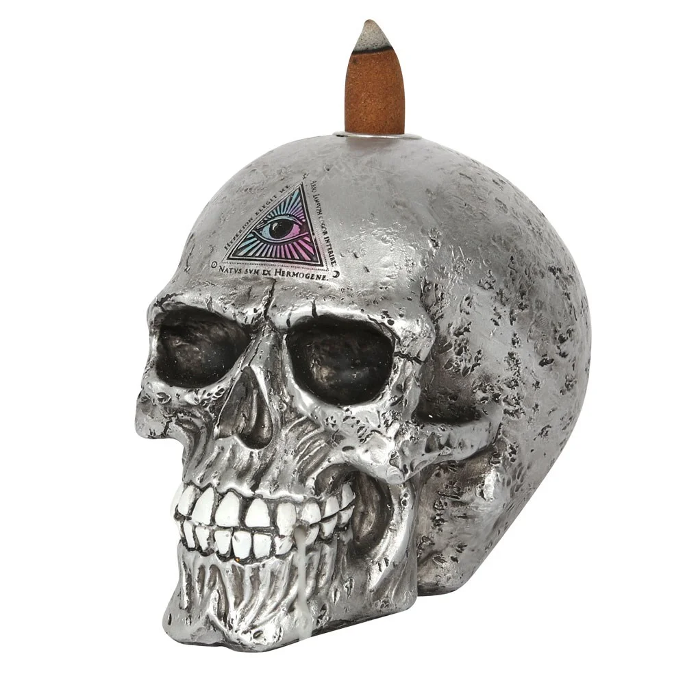 Silver skull backflow incense burner with all-seeing eye design by Alchemy, smoke flowing from mouth in swirls