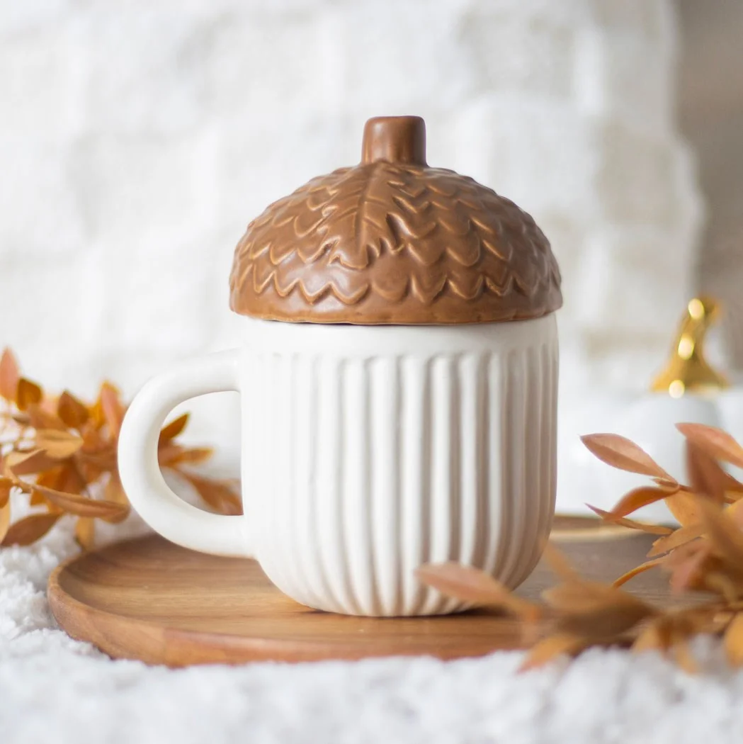 Autumn acorn mug with lid, shaped like an acorn, ceramic, designed to keep drinks hot, on a white background
