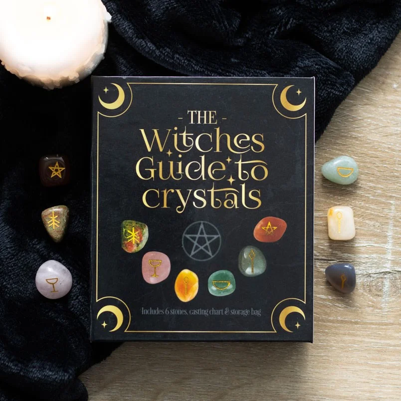 Witches guide to crystals gift set with six tumblestones, casting chart, velvet bag, and informational box on white background