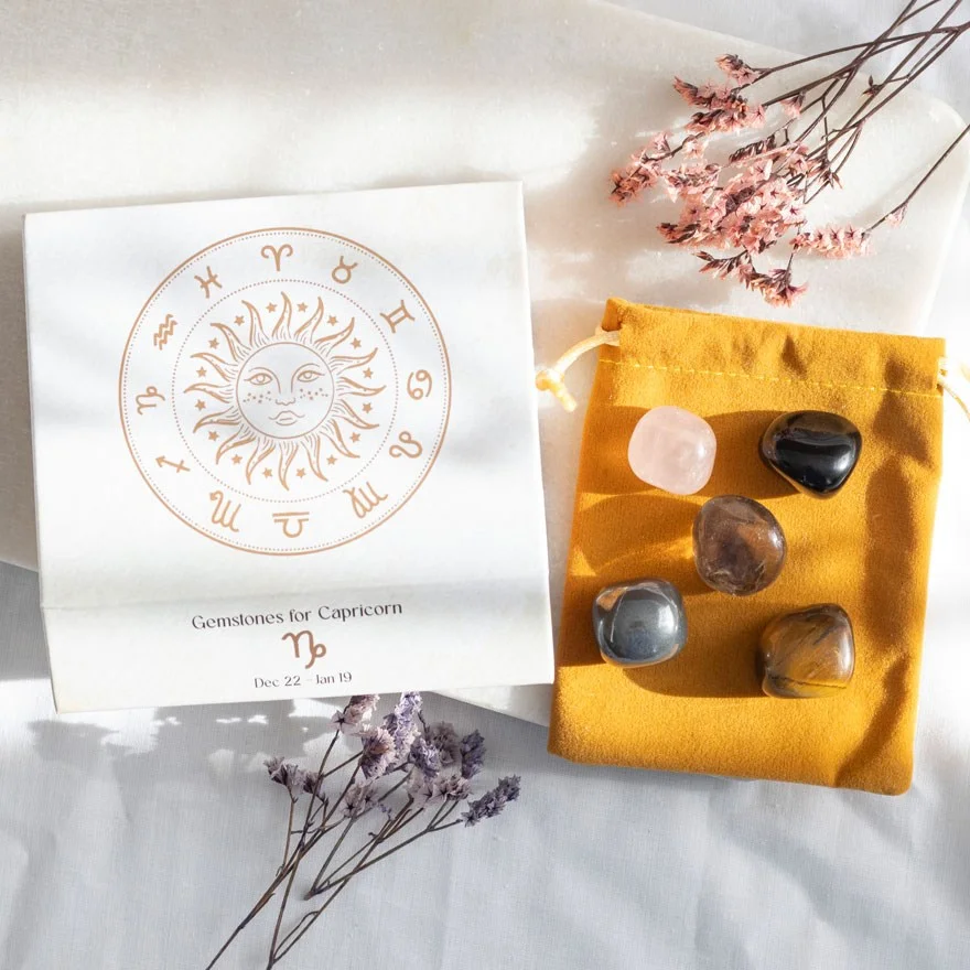 Five polished crystals including Rose Quartz and Tiger's Eye in a velvet bag, part of Capricorn crystal tumblestone set in gift box