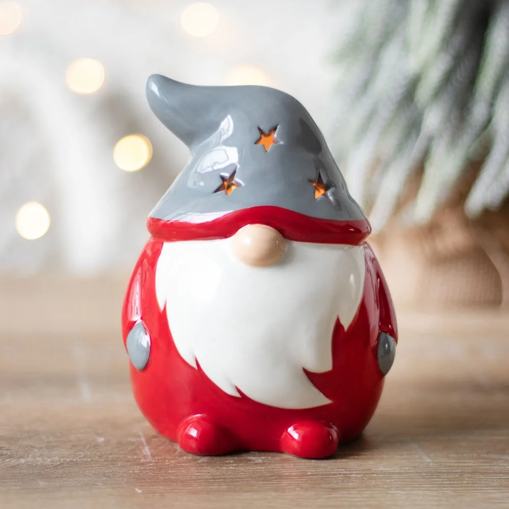 Red gonk tealight holder shaped like a festive gnome with a starry hat glowing softly from inside