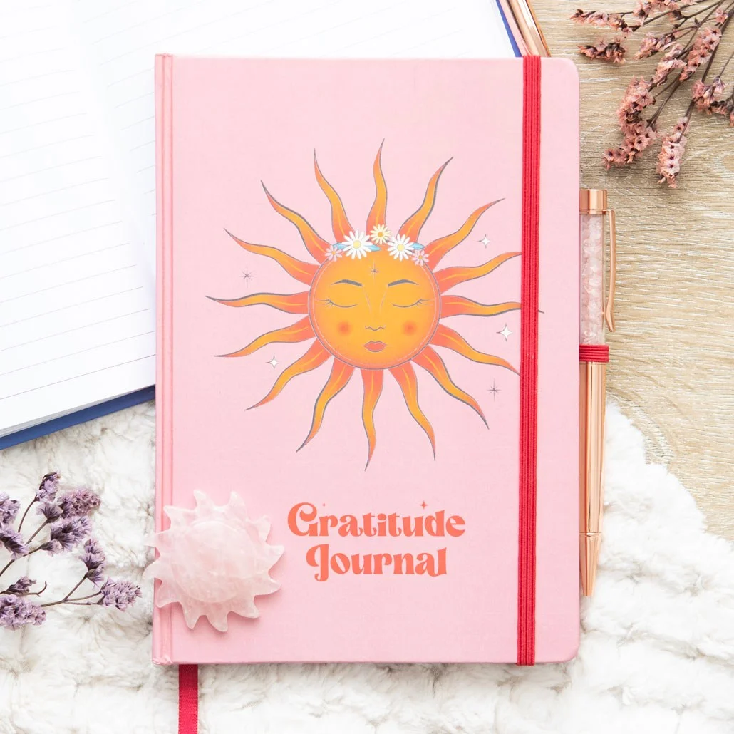 The Sun themed gratitude journal with vibrant cover and included rose quartz pen on white background