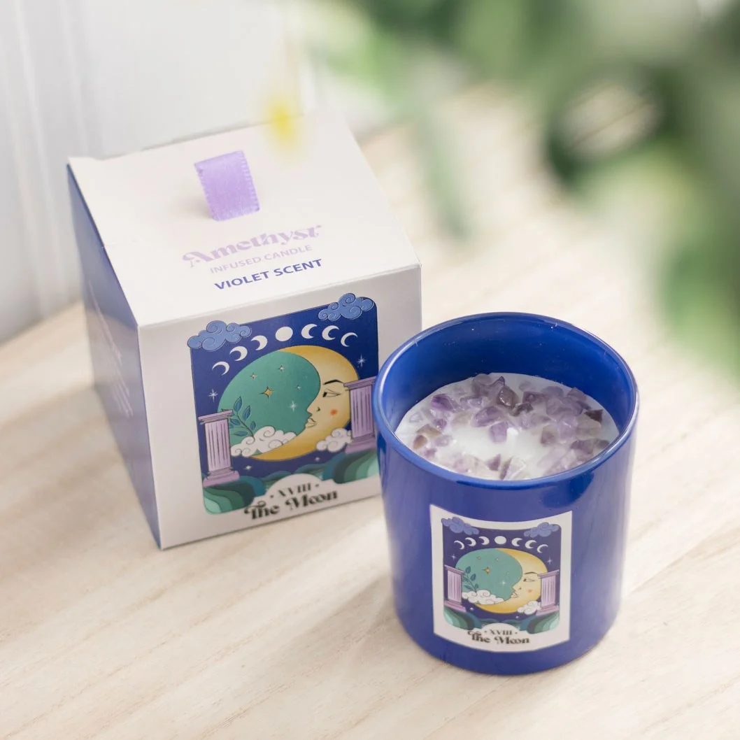 Blue glass amethyst crystal candle with violet scent and scattered amethyst chips inspired by The Moon tarot card design