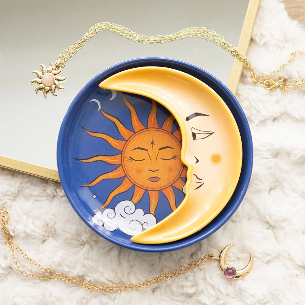 Circular celestial trinket dish set featuring a radiant sun design and a crescent moon dish stacked together on a white background