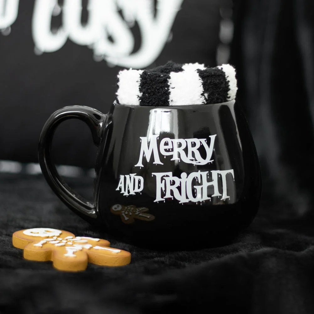 Black mug with "Merry and Fright" text and matching black and white striped socks in Merry and Fright mug set