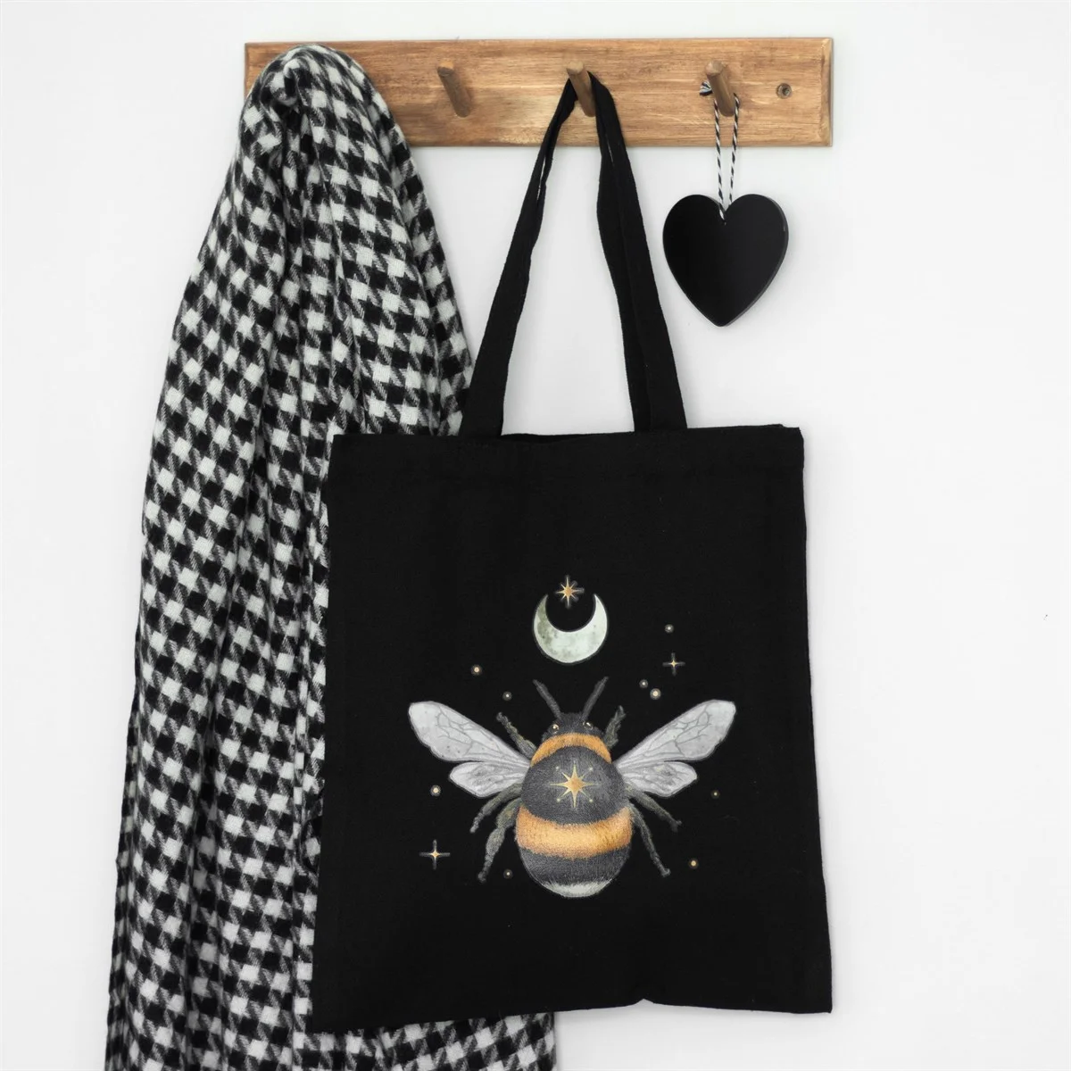 Black cotton tote bag with delicate forest bee design, spacious for everyday use or shopping.
