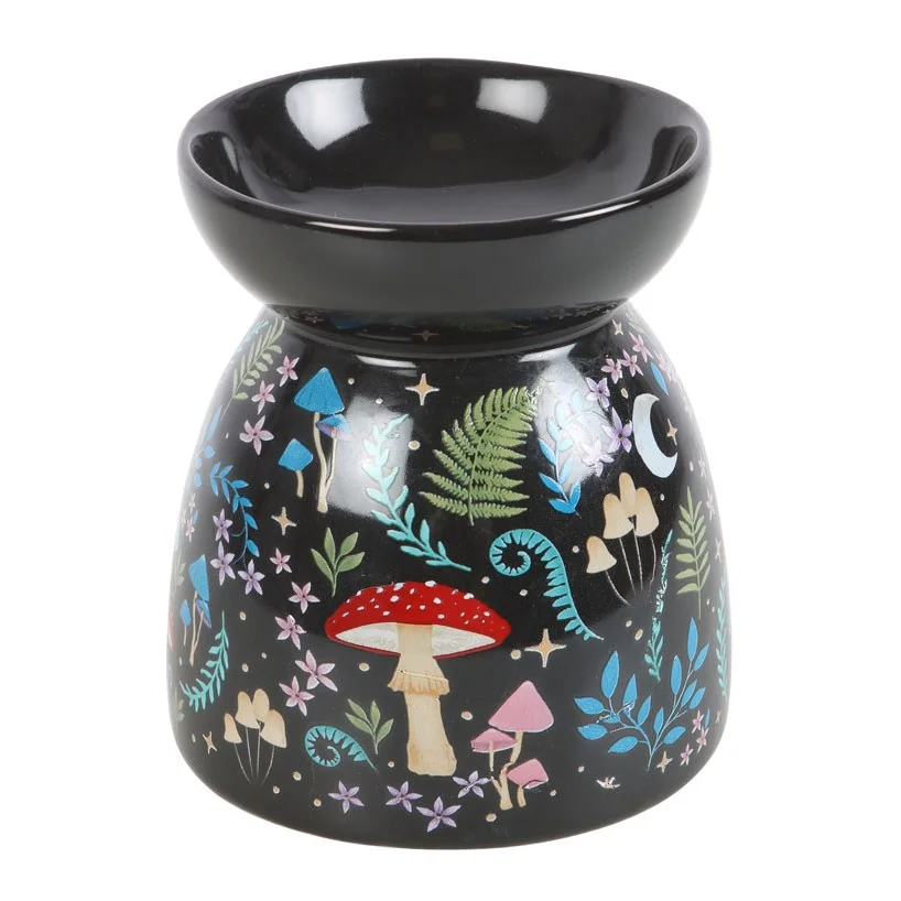 Black dark forest oil burner with colorful flora and fauna illustrations under moon and star glow on a white background
