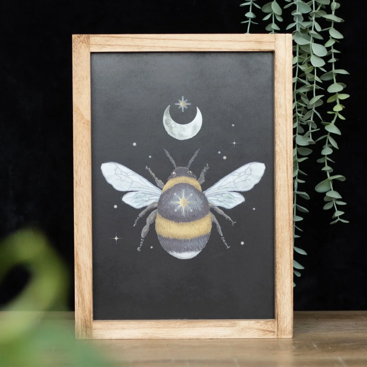 Framed wall print featuring an intricate forest bee design with crescent moon and stars in a wooden frame