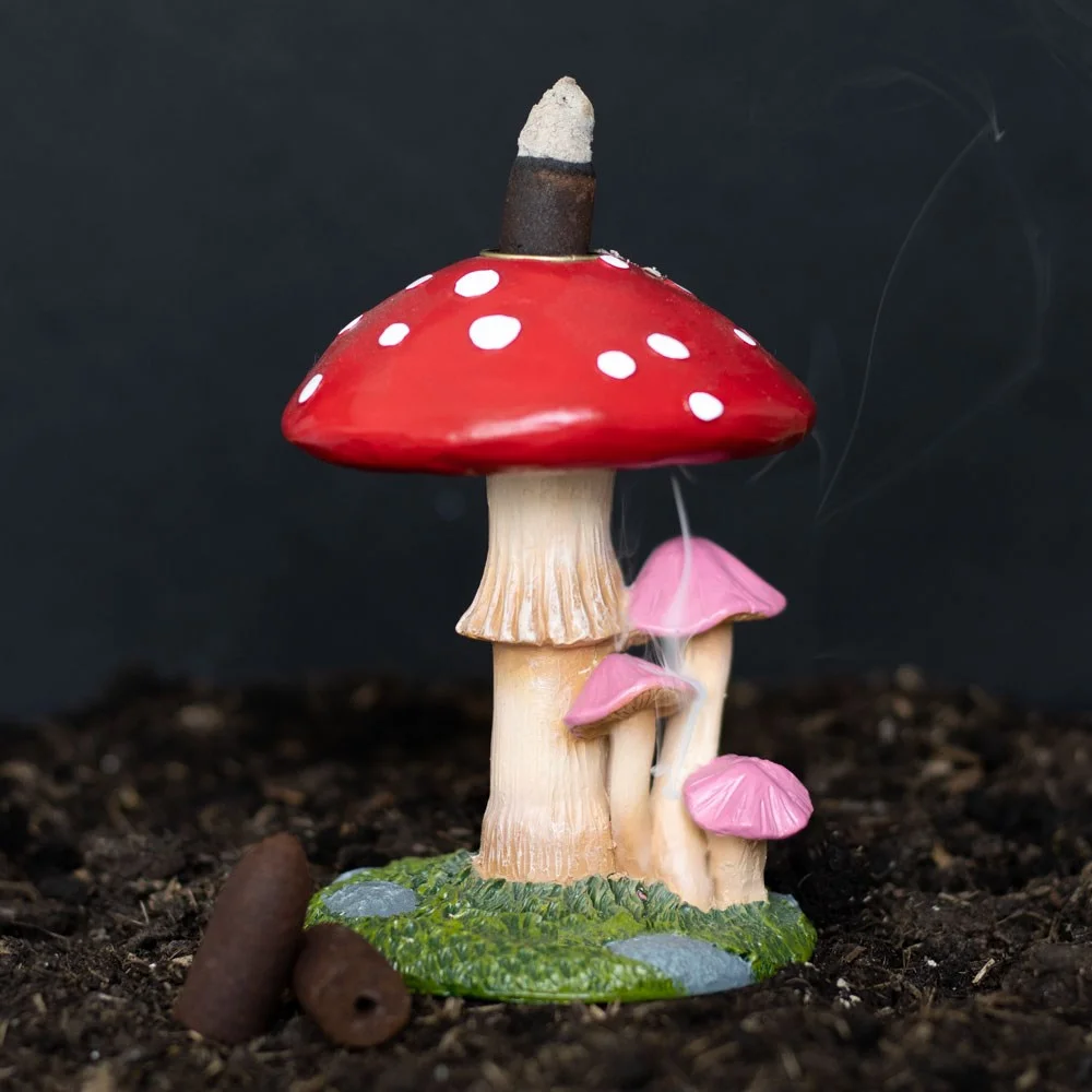 Whimsical mushroom incense burner shaped like a forest toadstool with smoke curling down from a backflow cone on top