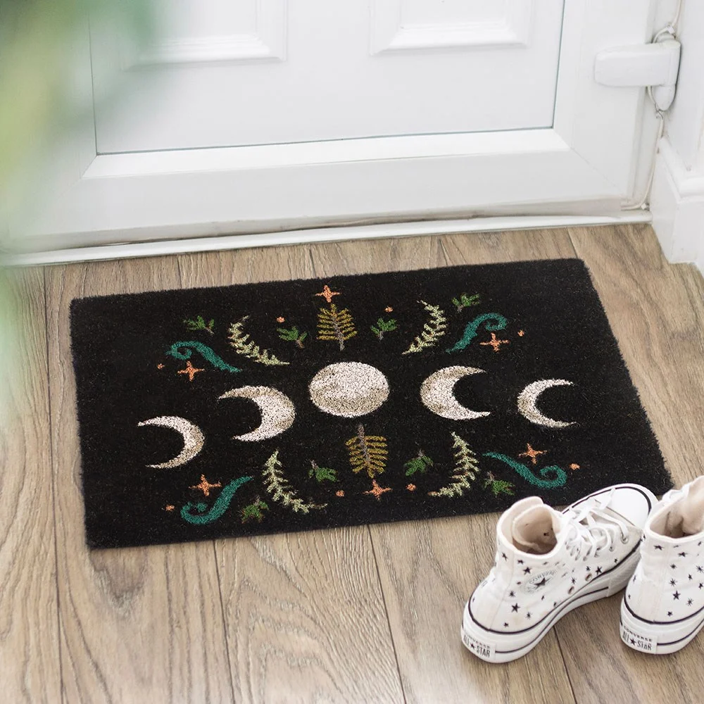 Black moon phase doormat with dark forest landscape and mystical plants.