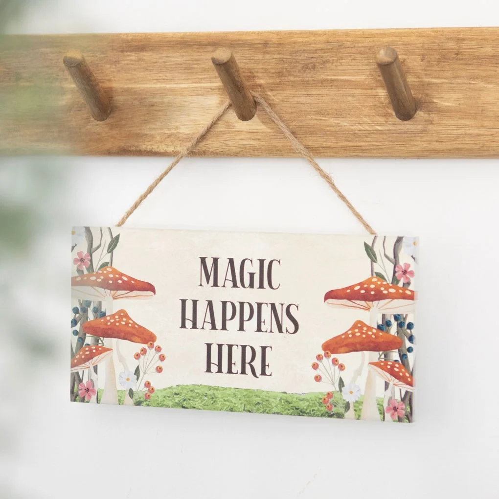 Whimsical mushroom hanging sign with toadstool design and "Magic Happens Here" text for enchanted forest decor