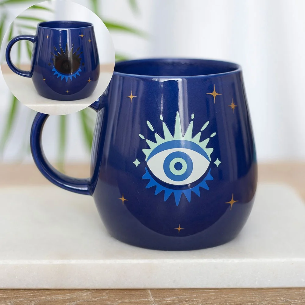 Colour changing mug showing the All Seeing Eye design that changes from closed to open when hot liquid is added