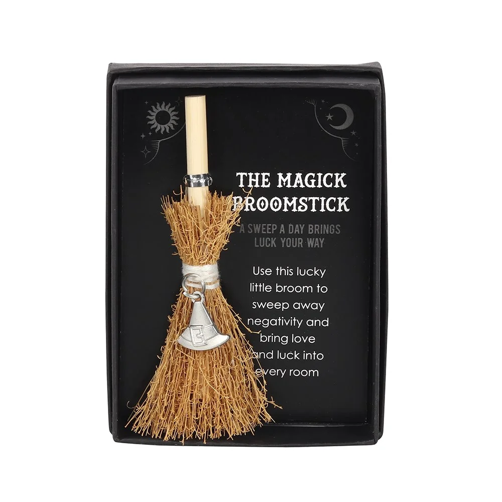 Mini magic broom with silver triple moon charm and written blessing, mounted on a small stand.