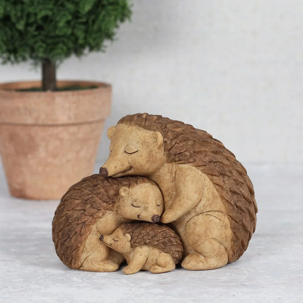Hedgehog family ornament showing two parent hedgehogs embracing their baby with a printed sentiment card