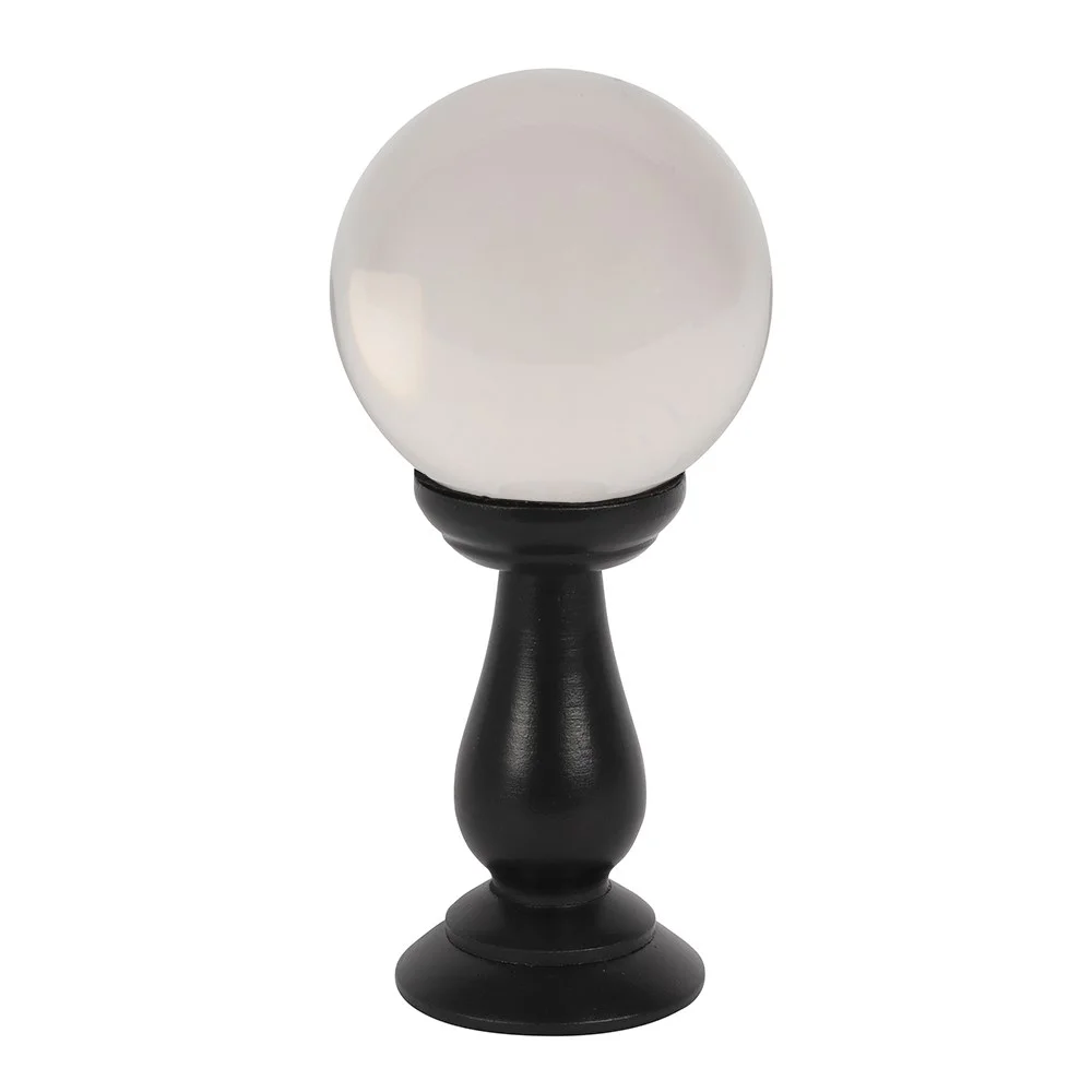 Clear crystal ball on a black wooden stand, surrounded by light, displayed as a decorative edition.