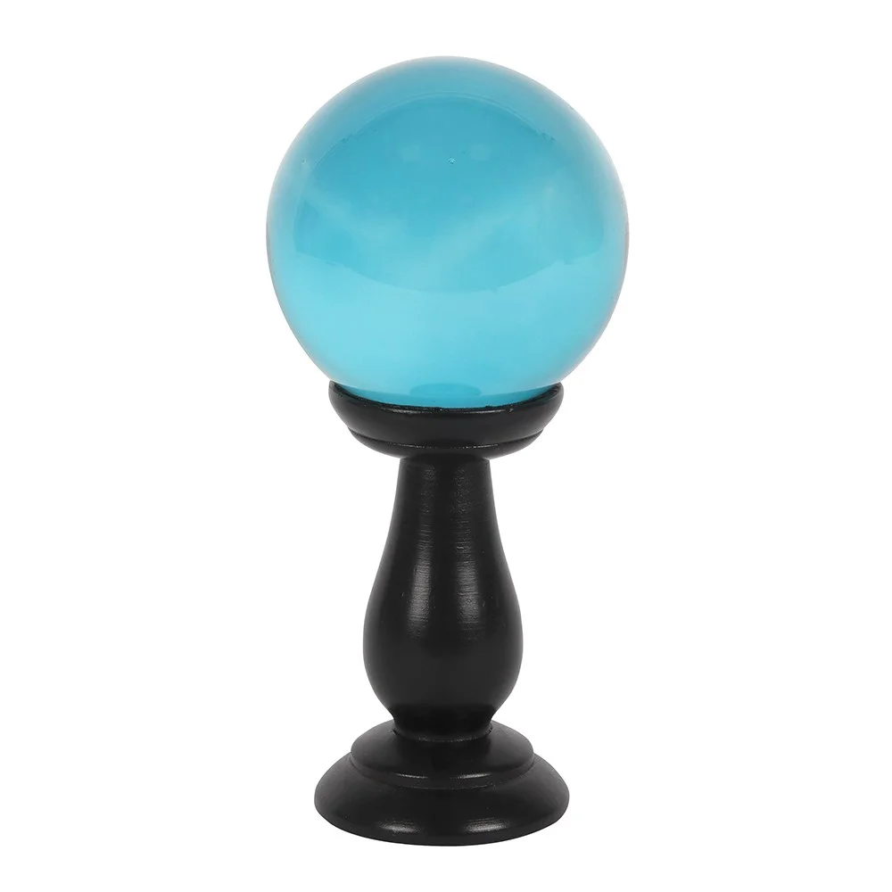 Teal crystal ball on black wooden stand, displayed as a small table accessory.