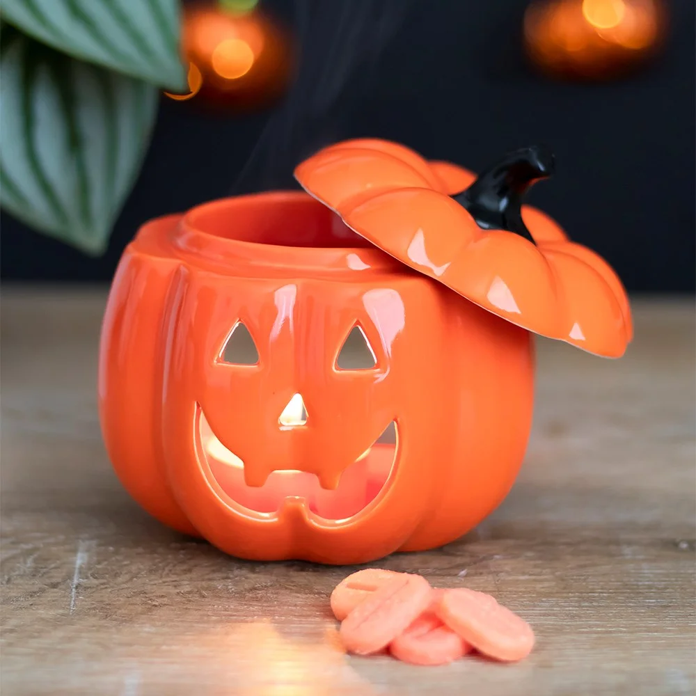 Smiling ceramic orange Jack-O-Lantern oil burner with lid, designed for tealight and fragrance oil use