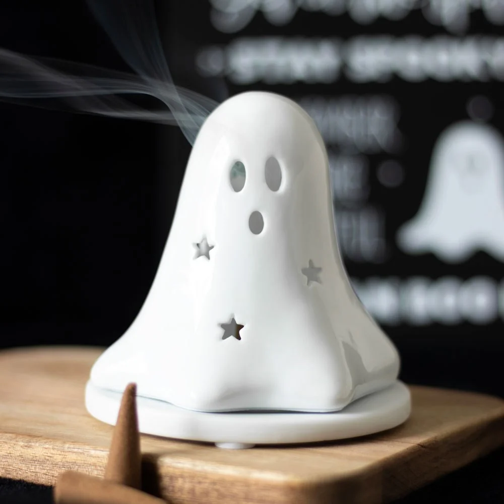 White ceramic ghost tealight holder with a hollow center, also used as an incense cone holder for Halloween decor