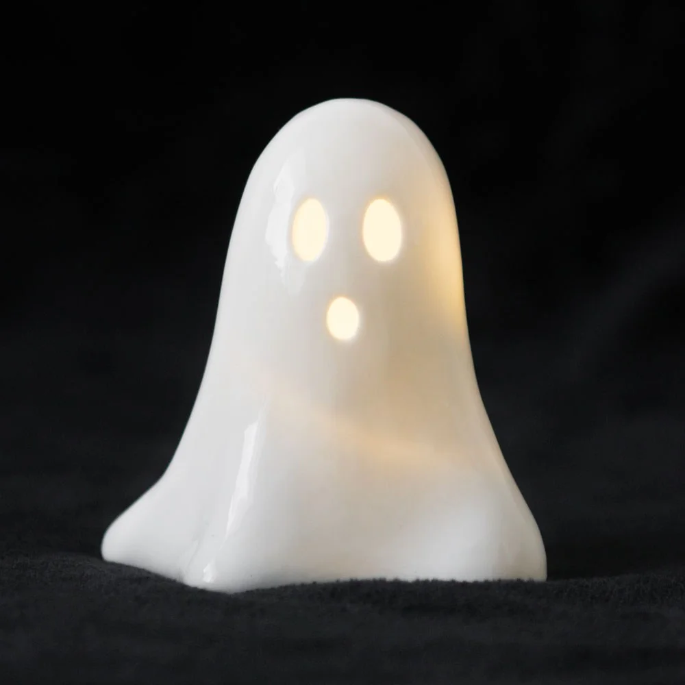 White ceramic light up ghost with friendly face and soft glow, battery-powered LED for Halloween decor