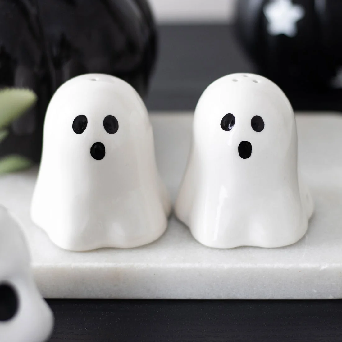 Pair of white ghost salt and pepper shakers with smiling faces for Halloween table decoration
