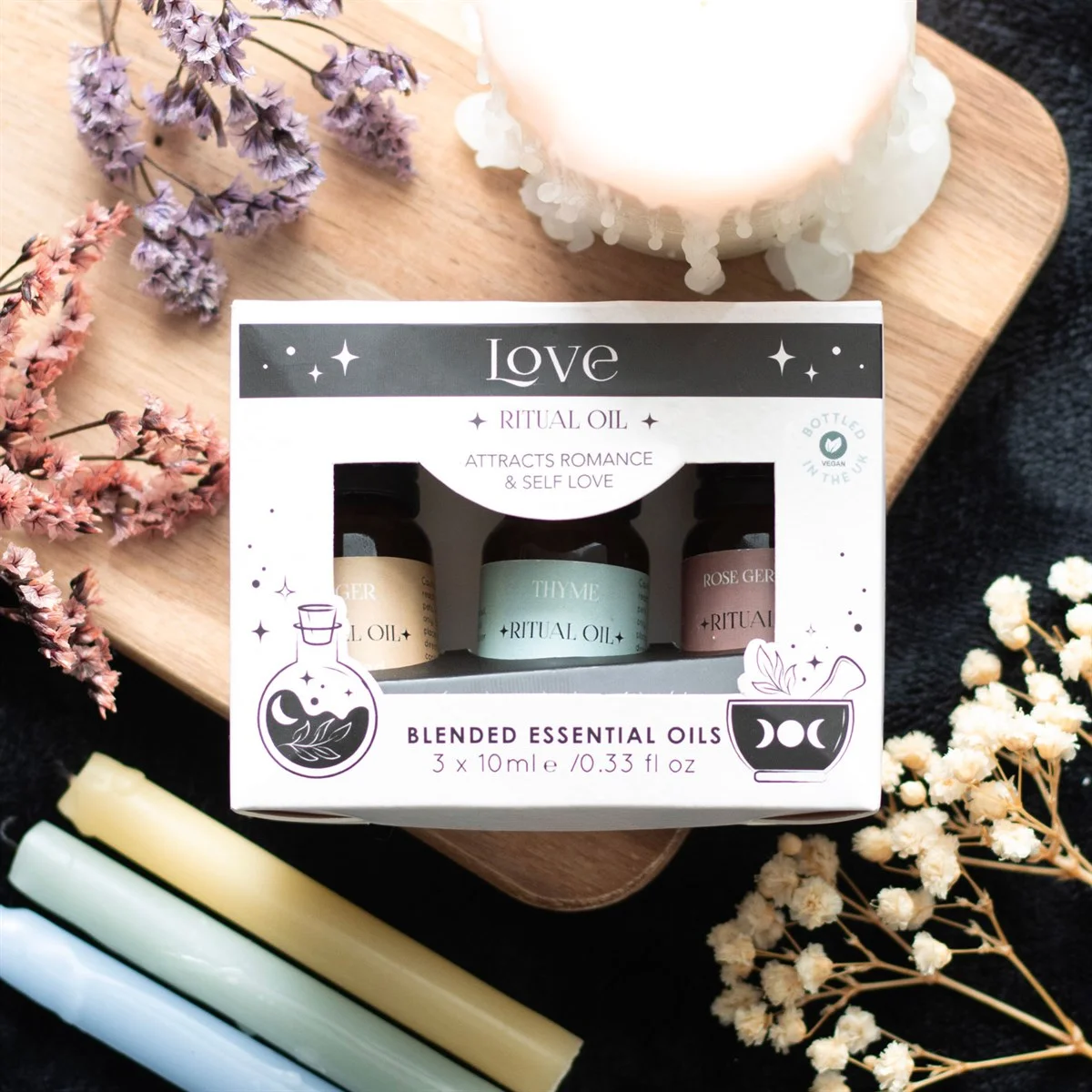Set of 3 love ritual essential oils bottles with labels featuring Thyme, Rose Geranium, and Ginger blends on white background