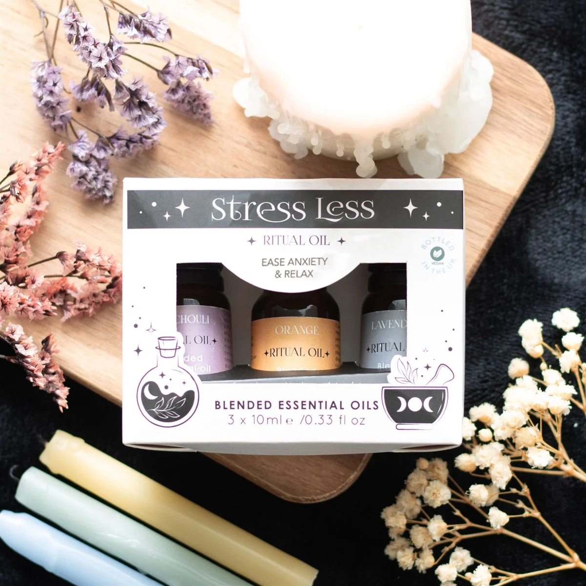 Set of three 10ml bottles of stress relief essential oils with orange, lavender, and patchouli blends on white background