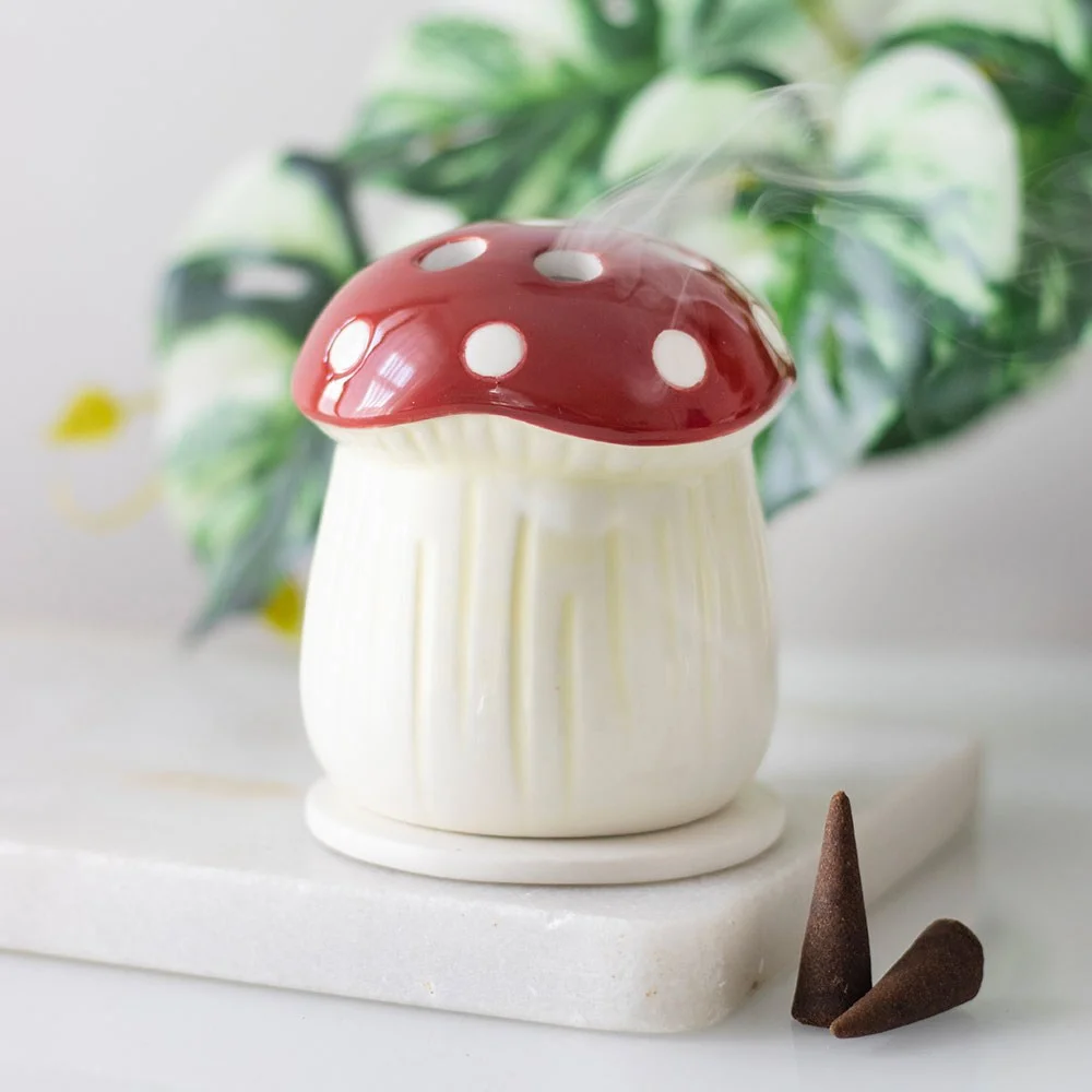 Red mushroom-shaped ceramic incense cone holder on a white background, bright and decorative accessory for home fragrance