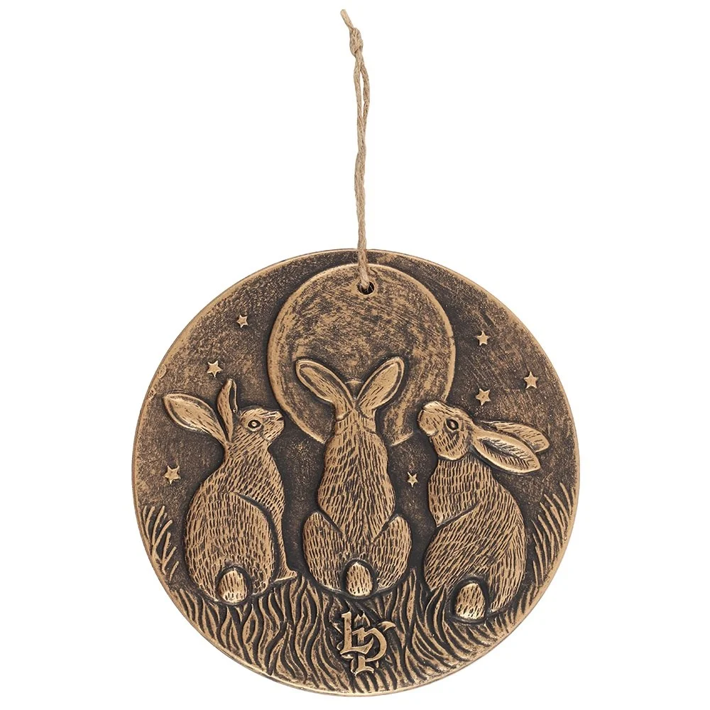 Bronze-effect terracotta wall plaque featuring three moon-gazing hares with a fertility and growth motif